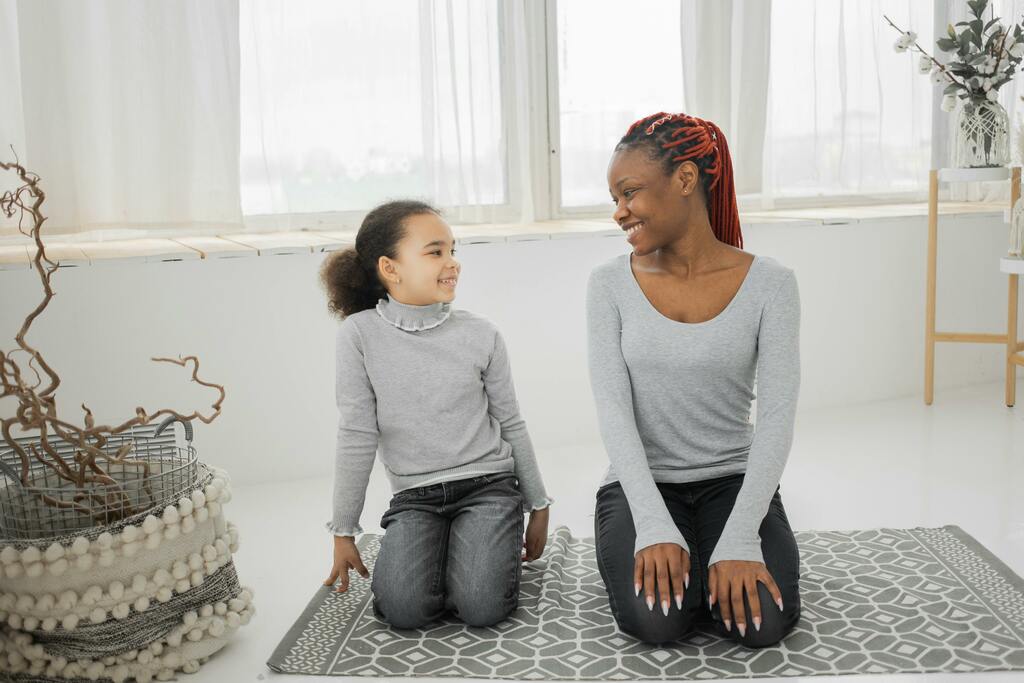Mother and daughter kneeling beside each other